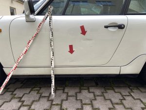 Firmenwagen-Unfall in München: Wer haftet? weißes Auto mit Unfalltüre