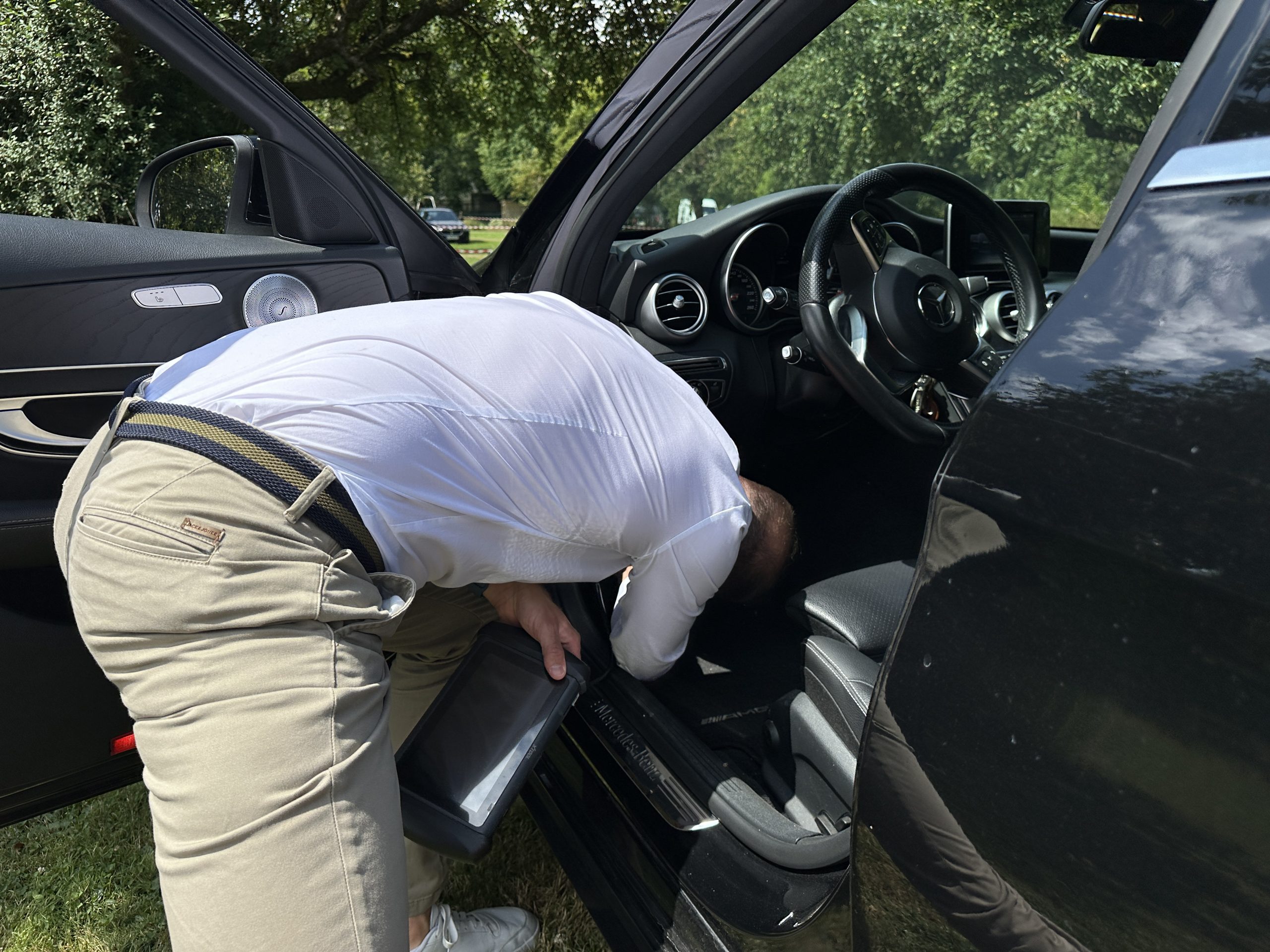 Wie geht es nach einem Unfall und gutachten weiter? Andreas Anzer beim Prüfen eines schwarzen Mercedes nach einem Unfall.